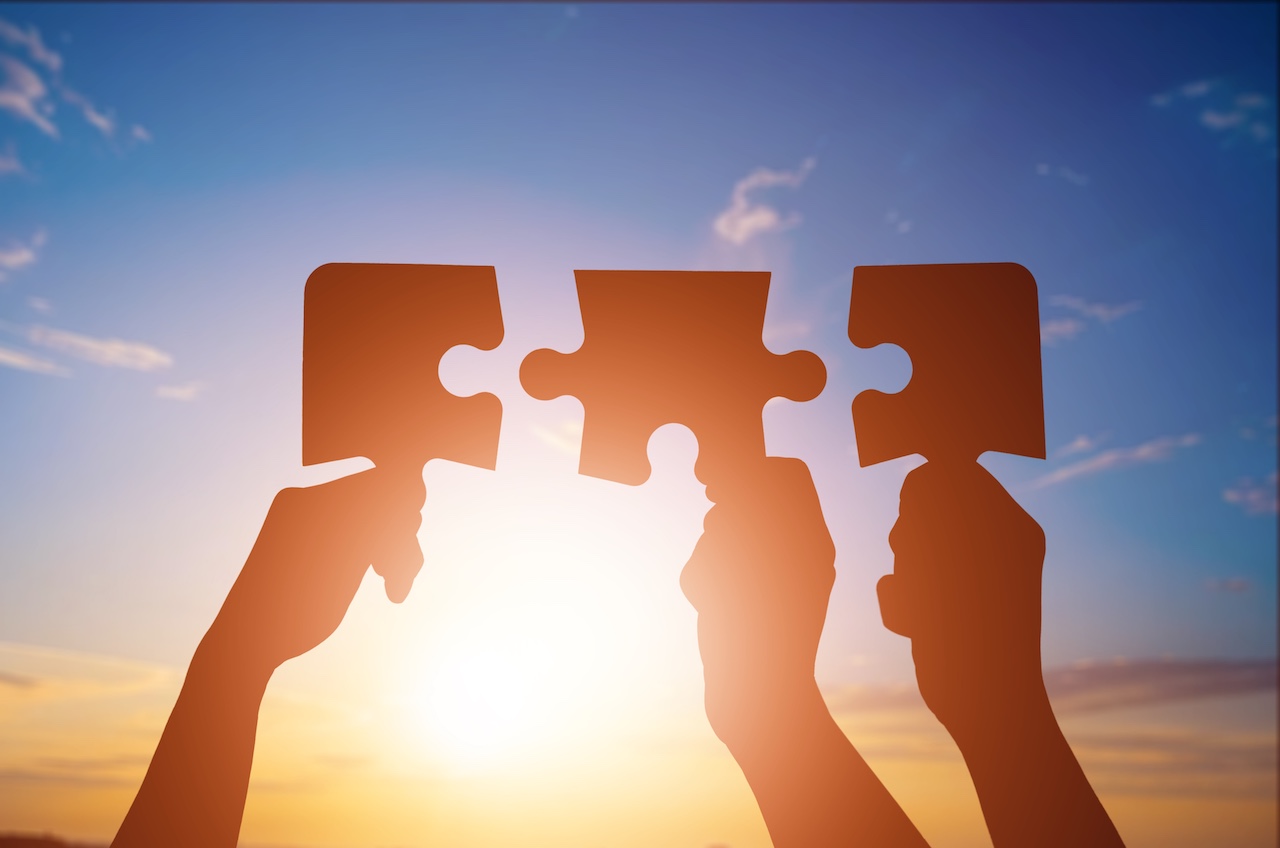 Concept of teamwork, hands joins puzzle pieces